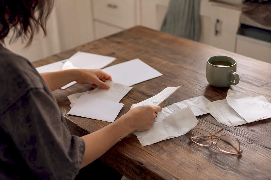 Hands organizing medical receipts at table