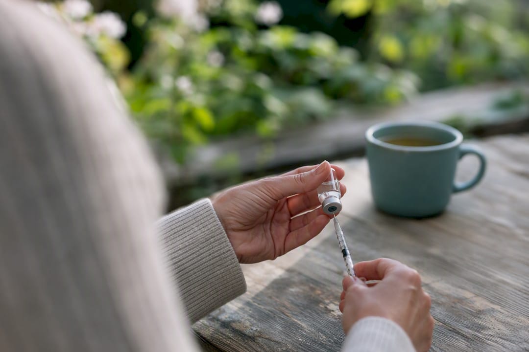 Hands preparing GLP-1 injection syringe